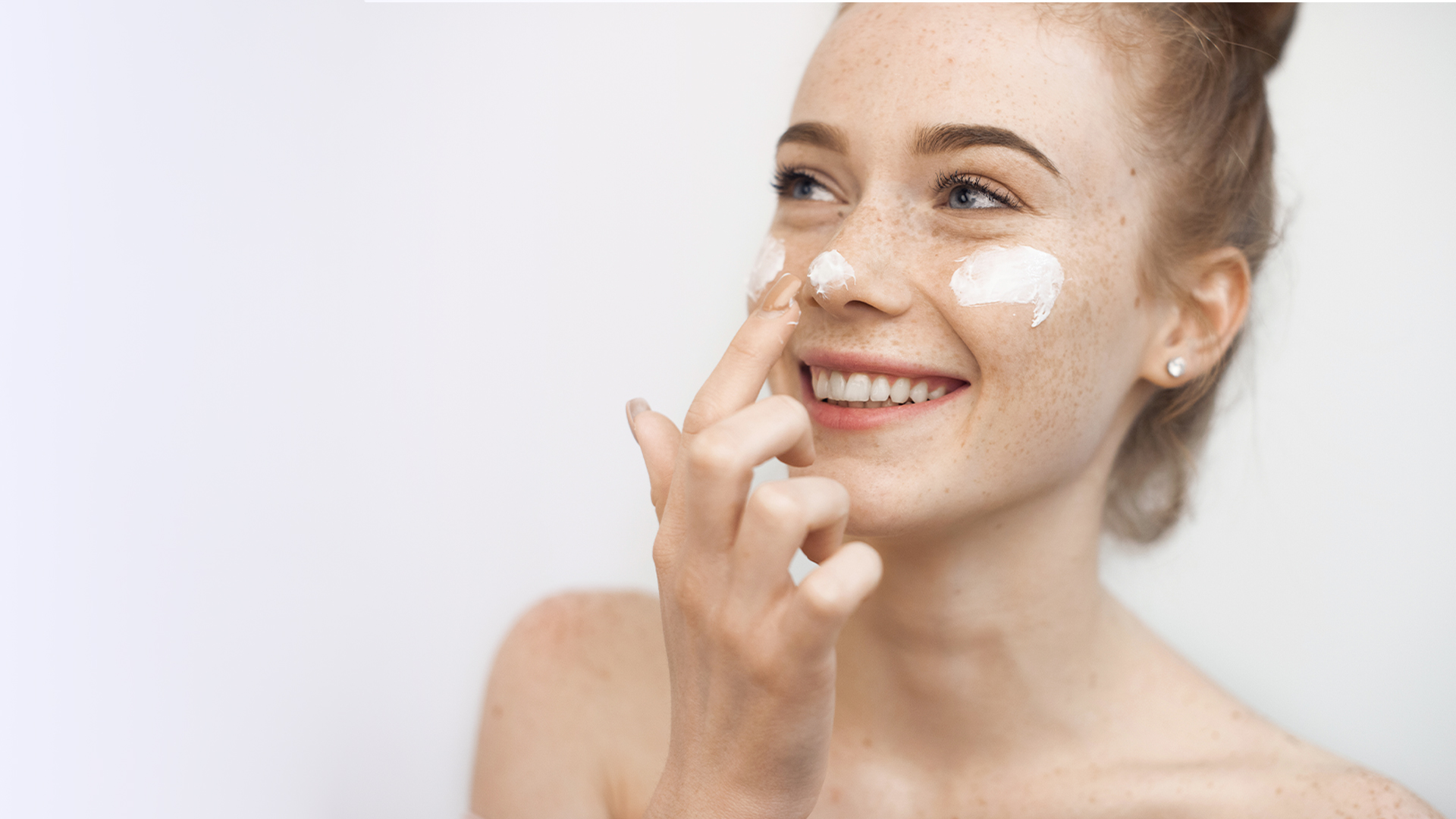 Mujer aplicandose crema de Bioderma en la cara